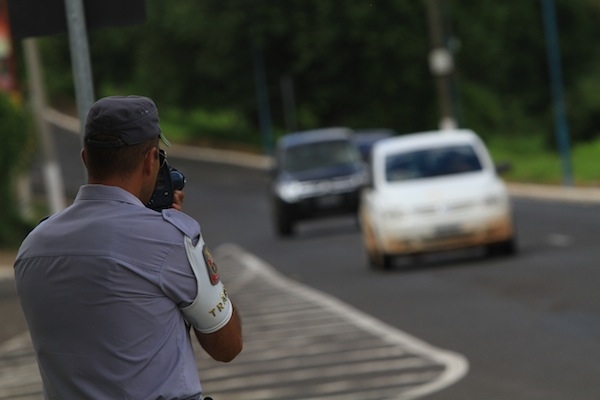 Policial militar maneja aparelho em avenida da cidade